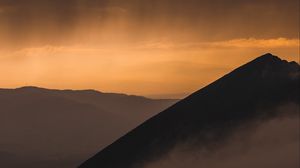 Preview wallpaper mountain, peak, fog, sunset, sky