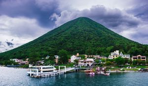 Preview wallpaper mountain, peak, sea, buildings, pier