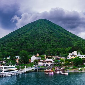 Preview wallpaper mountain, peak, sea, buildings, pier