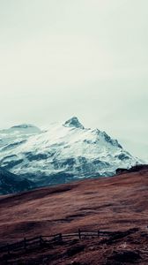 Preview wallpaper mountain, peak, snow, hut, fence