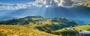 Preview wallpaper mountain, slope, flowers, lilies, sun, clouds, rays