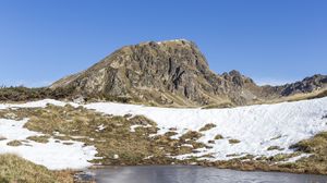 Preview wallpaper mountain, valley, snow, pond, grass