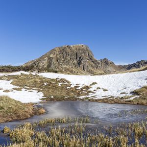 Preview wallpaper mountain, valley, snow, pond, grass