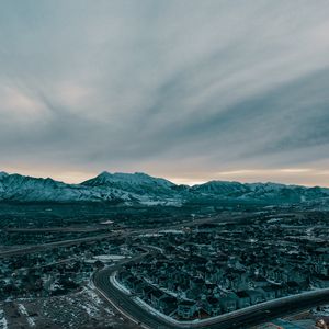 Preview wallpaper mountains, aerial view, village, snowy, sky