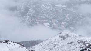 Preview wallpaper mountains, city, aerial view, fog, snow, clouds