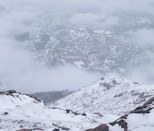 Preview wallpaper mountains, city, aerial view, fog, snow, clouds