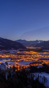 Preview wallpaper mountains, city, lights, snow, snowy, night