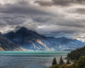 Preview wallpaper mountains, clouds, cloudy, rocks, water, multi-colored, lake