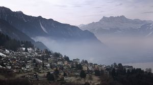 Preview wallpaper mountains, fog, buildings, city