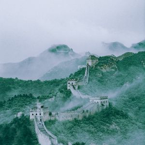 Preview wallpaper mountains, fog, wall, building, aerial view