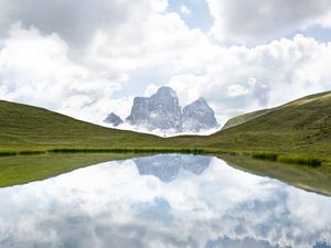 Preview wallpaper mountains, lake, man, grass, clouds