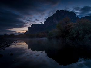 Preview wallpaper mountains, lake, reflection, trees, stones, fog, clouds