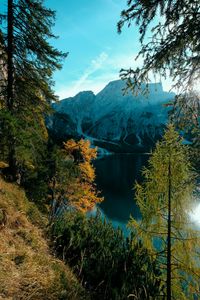 Preview wallpaper mountains, lake, trees, branches, sky, clouds