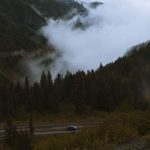Preview wallpaper mountains, pines, trees, fog, road, car, nature