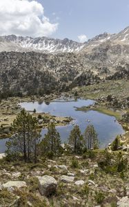 Preview wallpaper mountains, pond, trees, grass, stones, sky, clouds