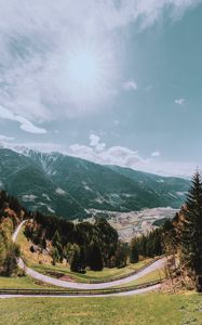 Preview wallpaper mountains, road, landscape, sun, trees, slope