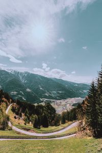 Preview wallpaper mountains, road, landscape, sun, trees, slope