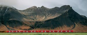 Preview wallpaper mountains, rocks, train, grass, fog