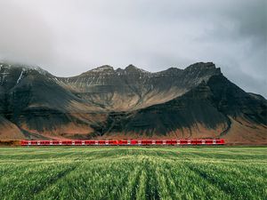 Preview wallpaper mountains, rocks, train, grass, fog