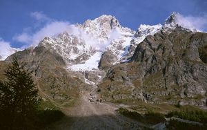 Preview wallpaper mountains, shadow, top, stones, grass, trees, clouds, fir-tree