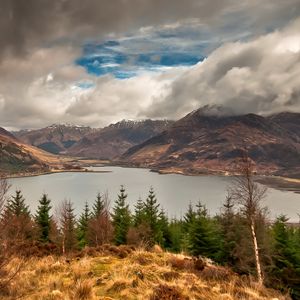 Preview wallpaper mountains, sky, lake, clouds, dense, wood, coniferous, birches, grass, faded, autumn, look, landscape