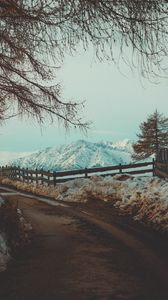 Preview wallpaper mountains, snow, road, fence, branches