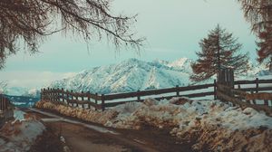 Preview wallpaper mountains, snow, road, fence, branches