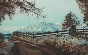 Preview wallpaper mountains, snow, road, fence, branches