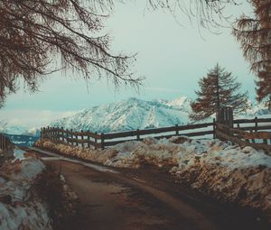 Preview wallpaper mountains, snow, road, fence, branches