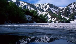 Preview wallpaper mountains, spring, snow, trees, slopes, shadow, coast, foam, lake