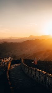 Preview wallpaper mountains, sunset, wall, building, people