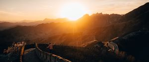 Preview wallpaper mountains, sunset, wall, building, people