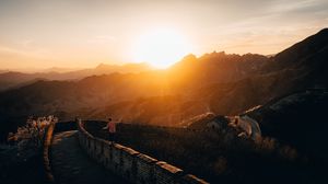Preview wallpaper mountains, sunset, wall, building, people
