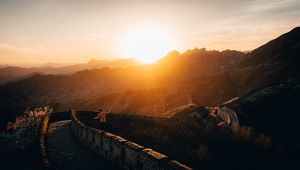 Preview wallpaper mountains, sunset, wall, building, people