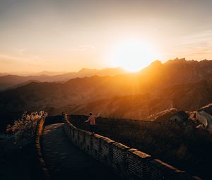 Preview wallpaper mountains, sunset, wall, building, people