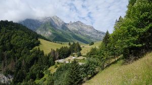 Preview wallpaper mountains, trees, clouds, grass, slope