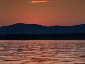 Preview wallpaper mountains, water, waves, glare, sunset