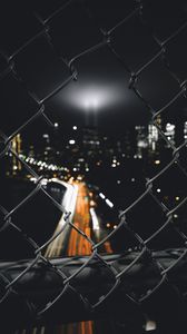 Preview wallpaper night city, fence, mesh, glare, blur