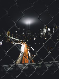Preview wallpaper night city, fence, mesh, glare, blur