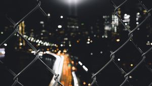 Preview wallpaper night city, fence, mesh, glare, blur