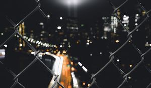 Preview wallpaper night city, fence, mesh, glare, blur