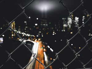 Preview wallpaper night city, fence, mesh, glare, blur