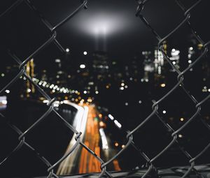 Preview wallpaper night city, fence, mesh, glare, blur