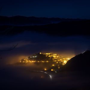 Preview wallpaper night, city, lights, mountains, fog, italy, aerial view