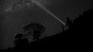 Preview wallpaper night, starry sky, man, flashlight, glow