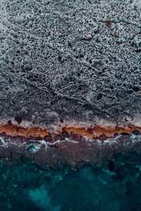 Preview wallpaper ocean, coast, aerial view, water, stones, surface, ribbed