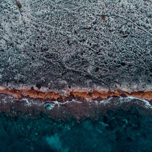 Preview wallpaper ocean, coast, aerial view, water, stones, surface, ribbed