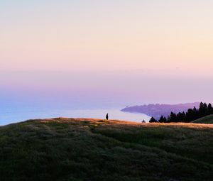 Preview wallpaper ocean, coast, horizon, hills, silhouette, fog