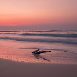 Preview wallpaper ocean, coast, sunset, cobble, sand, horizon