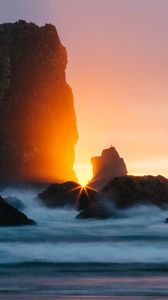 Preview wallpaper ocean, rock, sunset, rays, surf